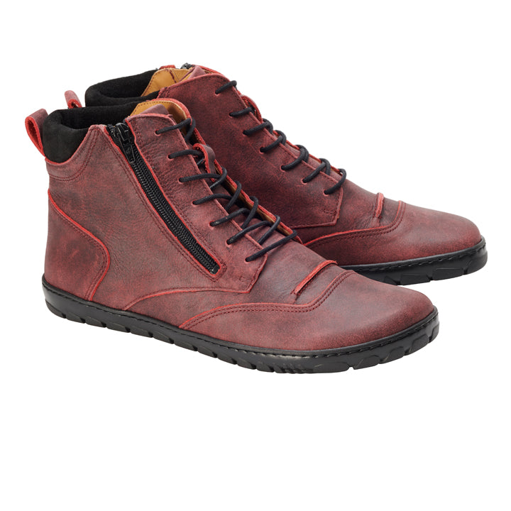 Die ZAQQ PARQER Red Stiefel sind hohe, burgunderfarbene Lederschuhe aus Premium-Nappaleder mit schwarzer Sohle, Schnürung vorne und praktischen seitlichen Reißverschlüssen. Mit minimalen Nähten und einem leicht abgenutzten Finish bieten diese Stiefel verbesserten Komfort durch gepolsterte Details um den Knöchel. Sie werden als Paar nebeneinander präsentiert.