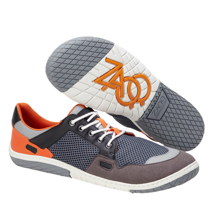 Die NUQA Grey Sneaker von ZAQQ bestechen durch ihr schickes Design mit einem grauen Obermaterial aus veganem Mesh, auffälligen orangefarbenen Akzenten und einer weißen flexiblen MINIMAL-Sohle mit dem Logo der Marke. Die weißen Schnürsenkel betonen die schwarzen und grauen Details und sorgen für einen mühelos stilvollen Auftritt.