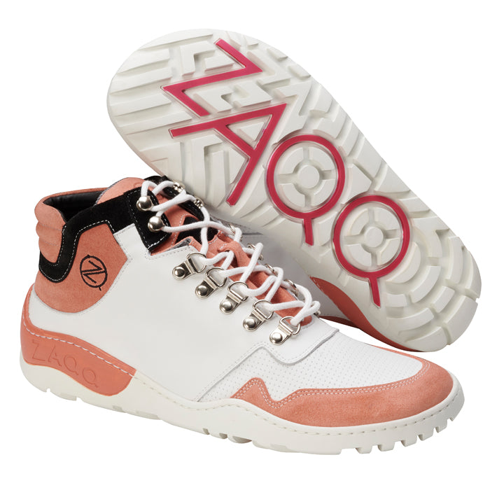 Ein Paar schicke High-Top-Sneaker mit weißer Basis und rosa und schwarzen Akzenten, komplett mit silbernen Ösen. Die Sohle ist für höchste Atmungsaktivität ausgelegt und mit einem rosa ZAQQ-Logoaufdruck verziert. Ein Schuh steht gerade, während der andere sein Profil zeigt, was sie ideal für jedes ZAQQ VAQATION Rosa Waterproof-Abenteuer macht.