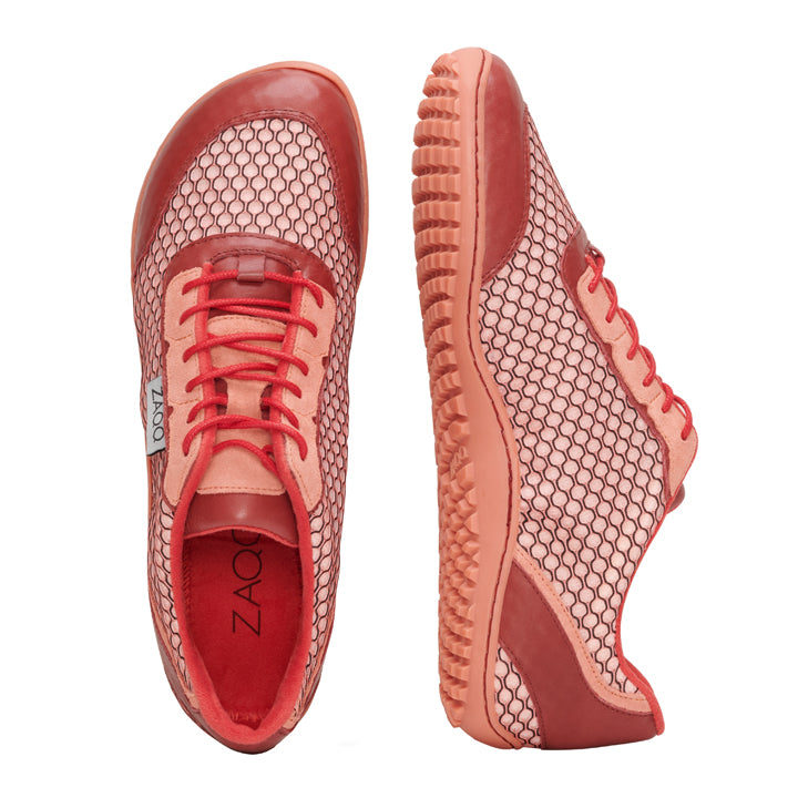 Ein Paar modische TOQIO Coral-Sneaker von ZAQQ mit einem unverwechselbaren Mesh-Design und strukturierten Sohlen. Die Anzeige umfasst einen Schuh von der Seite und den anderen von oben, wodurch das komplizierte Muster und die leuchtende Farbe zur Geltung kommen und die Essenz eines stilvollen Barfußschuhs mit seiner natürlichen ZAQQ Sneakersohle-Textur hervorgerufen wird.