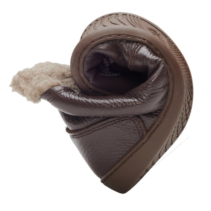 Der Lederschuh PREQUEL Winter Nappa Brown von ZAQQ mit kuscheligem Innenleben ist elegant spiralförmig gedreht und demonstriert so seine Flexibilität und Weichheit vor einem schlichten weißen Hintergrund.