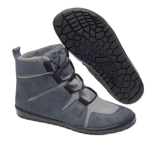 Wir präsentieren den DAQOTA Waterproof Grey von ZAQQ: Diese vielseitigen High-Top-Sneaker sind in Grau mit schwarzer, flexibler Sohle gefertigt und ideal für Outdoor-Abenteuer. Sie sind mit Schnürung vorne und einer Kombination aus Wildleder und Mesh-Materialien gestaltet und verfügen über eine praktische Schlaufe an der Rückseite für einfaches Tragen. Ein Schuh steht aufrecht, während der andere sein Sohlendesign zeigt, was sie zu einer ausgezeichneten Wahl für jeden Barfußschuh-Liebhaber macht.