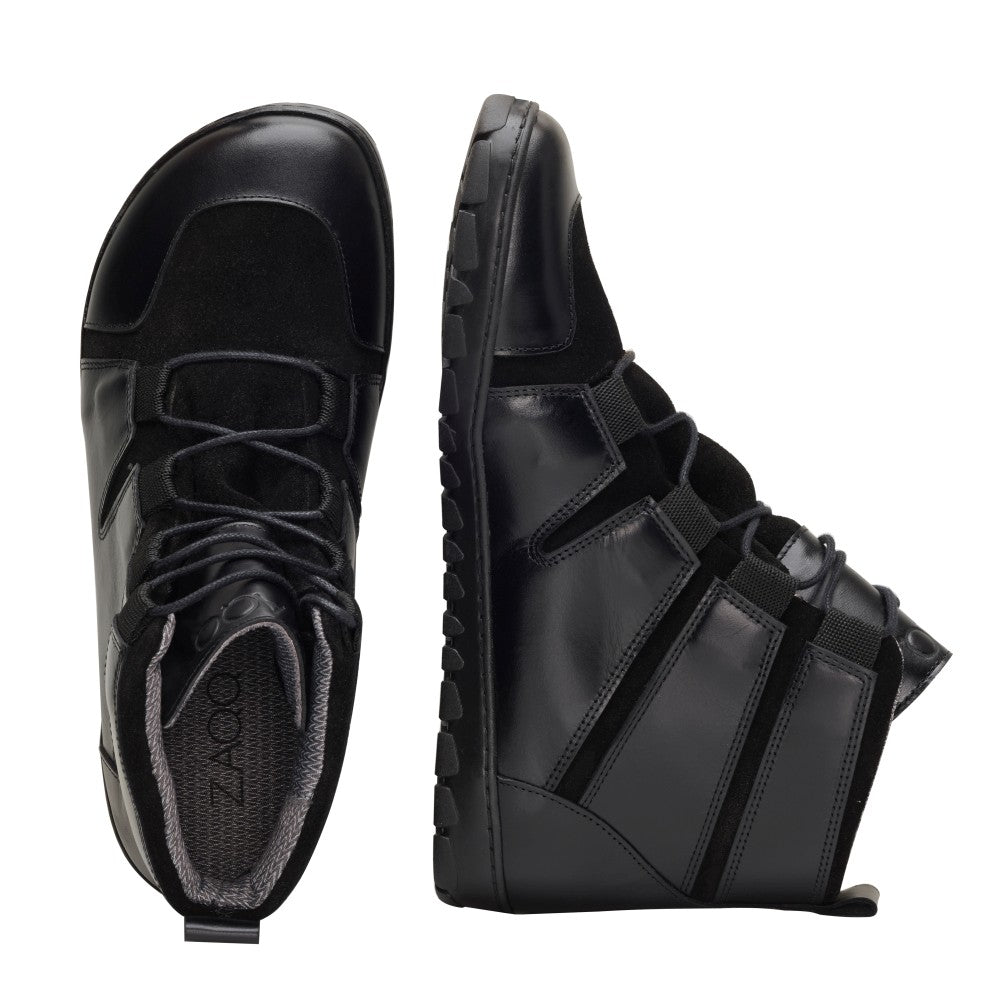 Ein Paar schwarze High-Top-Schuhe aus Leder von ZAQQ mit aufwendigen Schnürdetails und einer innovativen Outdoorsohle zeigt außergewöhnliche Handwerkskunst. Der linke Schuh wird aufrecht präsentiert, um die Seitenansicht hervorzuheben, während der rechte Schuh vertikal steht, um die Sohle und die Designdetails zu präsentieren und eine perfekte Mischung aus Stil und Haltbarkeit zu bieten.