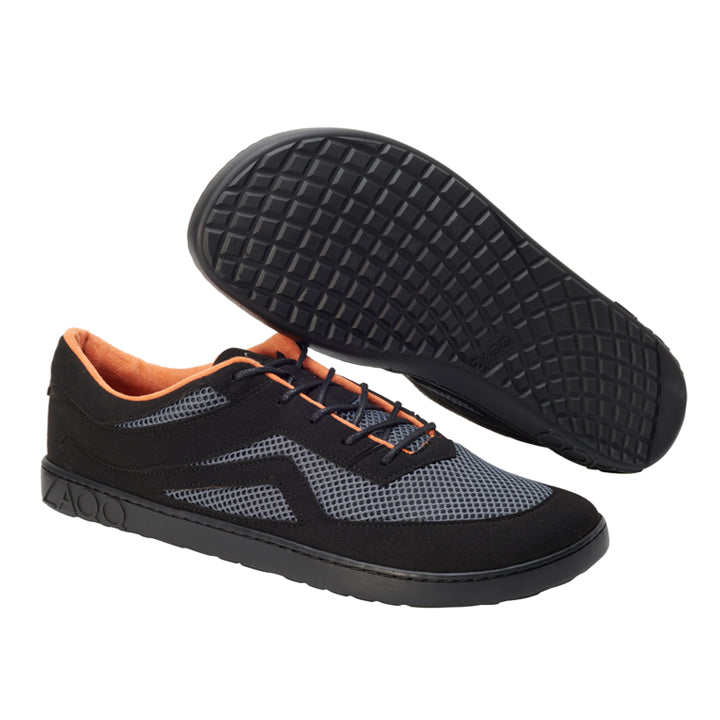 Präsentiert werden die QYNLEE Black Sneaker von ZAQQ mit einem Mesh-Design mit orangefarbenen Akzenten im Inneren. Mit einem ultramodernen Look wird ein Schuh aufrecht präsentiert, während der andere seine Waffelsohle zeigt und so Stil mit Funktion verbindet.