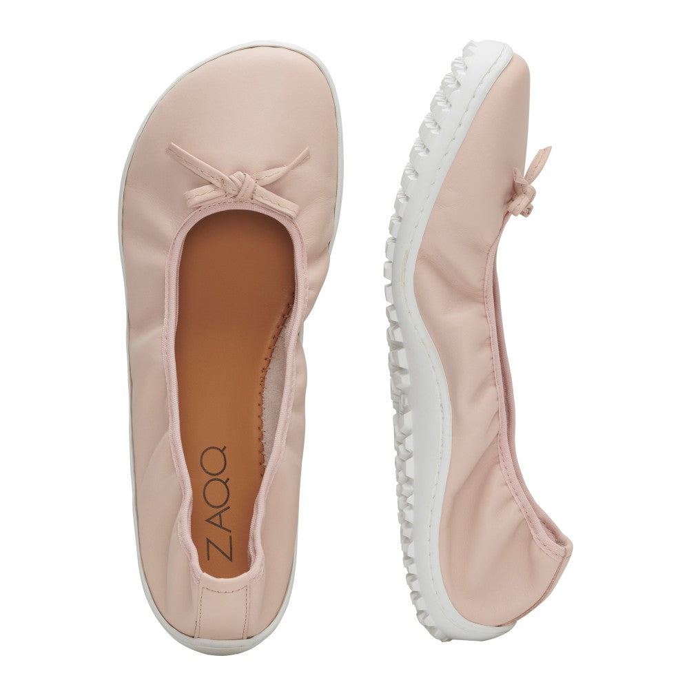 Die SUQAR Nude Ballerinas von ZAQQ verleihen mit ihrer hellrosa Farbe und den kleinen Schleifen oben einen femininen Touch. Ein Schuh ist von oben zu sehen, während der andere auf der Seite liegt und eine strukturierte weiße Sohle präsentiert. Die Innenseite ist fachmännisch aus Nappaleder gefertigt und trägt elegant den Markennamen ZAQQ.